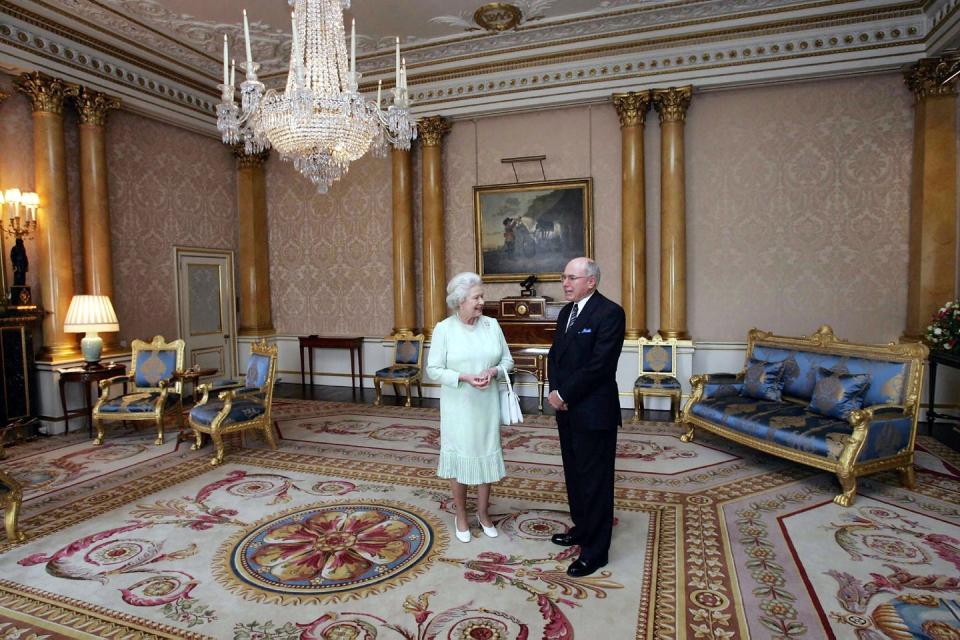 <p>The monarch chats with Australian Prime Minister John Howard on what might be one of the most regal-looking carpets in the palace. </p>