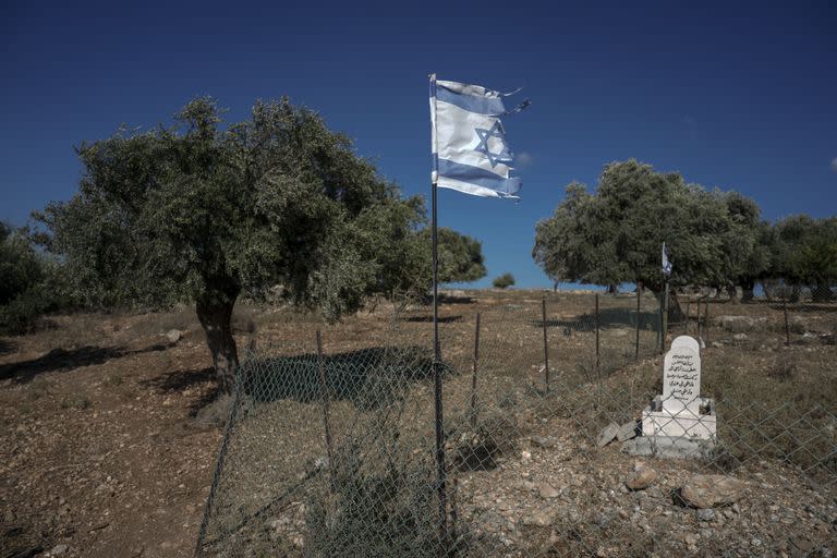 Bandera israelí desgarrada en un cementerio de beduinos árabes muertos sirviendo en las fuerzas armadas de Israel cerca de Zubaydat, en Galilea (Israel), en foto del 23 de agosto del 2022. (AP Photo/Ariel Schalit)