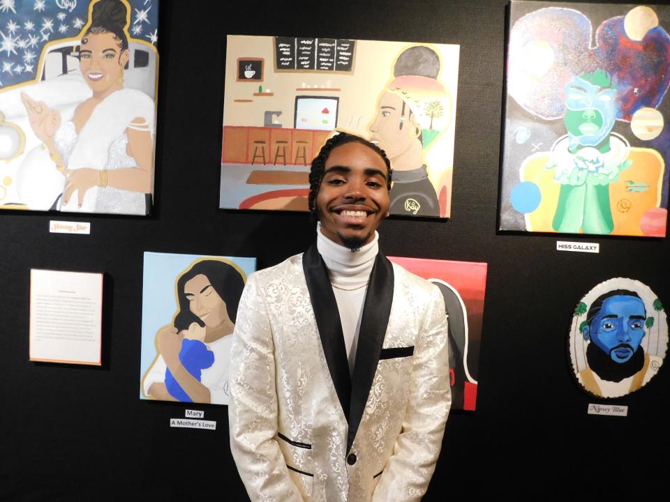 Local artist K'Shawn Collins stands with some of his acrylic paintings at a shared Opelousas Museum and Interpretative Center exhibit in the downtown business district.