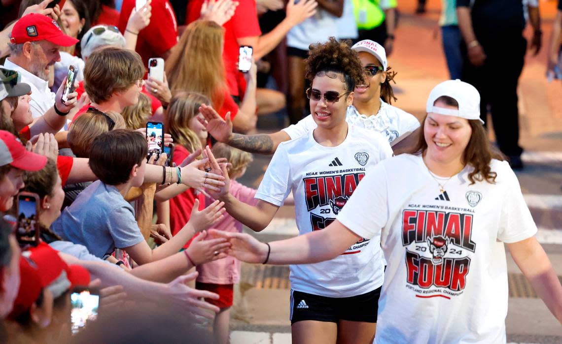 Fans greet women’s basketball players including N.C. State’s Madison Hayes, center, as they walk to the belltower during a celebration for the N.C. State men’s and women’s basketball team at the Memorial Belltower in Raleigh, N.C., Monday, April 15, 2024. Both teams made it to the NCAA Tournament Final Four and the men’s team won the ACC Championship by winning five games in five days.