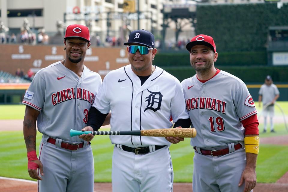 Joey Votto (right) with Reds teammate Will Benson, presenting Tigers star Miguel Cabrera with a retirement give Thursday in Detroit.