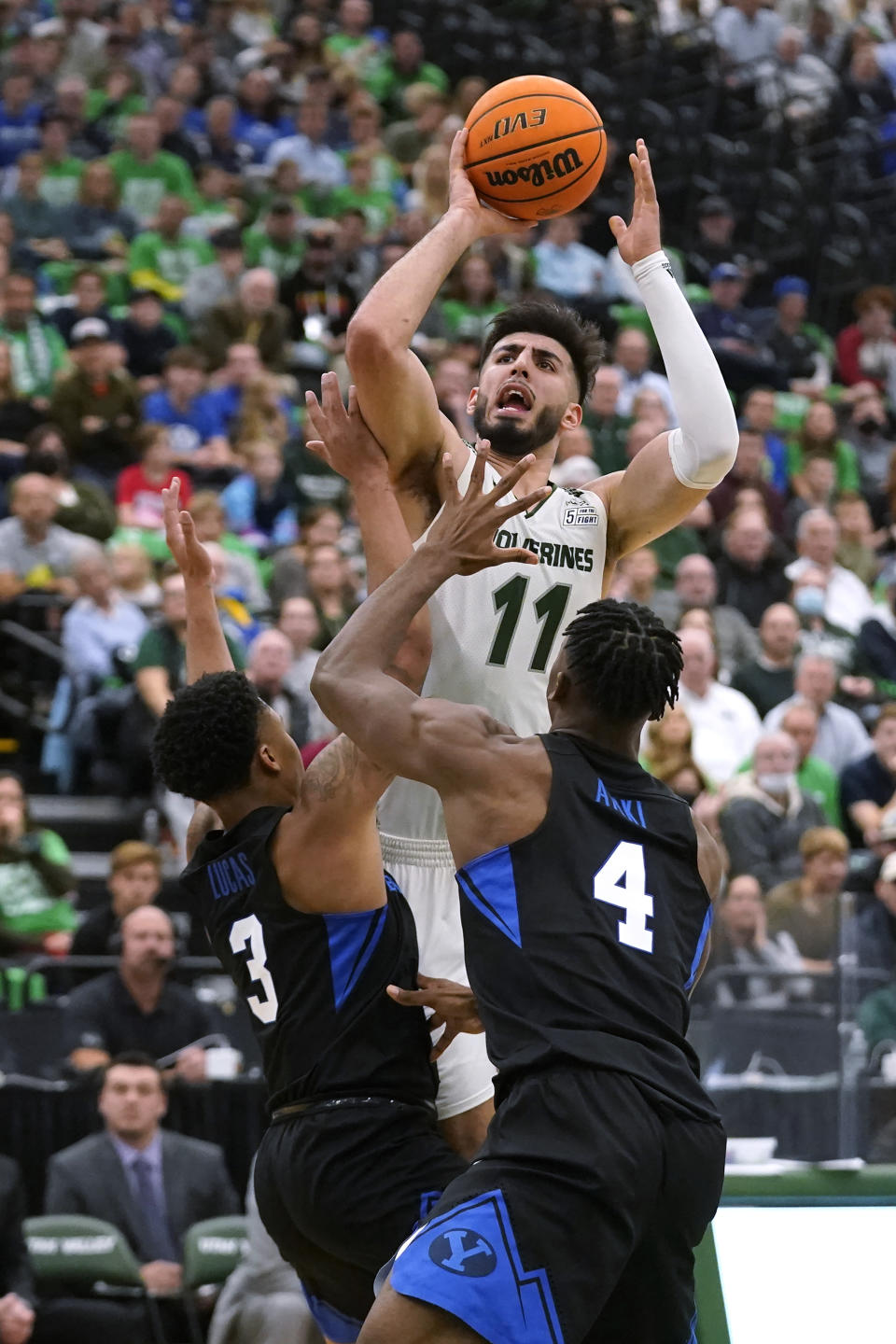 FILE - Utah Valley center Fardaws Aimaq (11) shoots as BYU's Te'Jon Lucas (3) and Atiki Ally Atiki (4) defend during the second half of an NCAA college basketball game Wednesday, Dec. 1, 2021, in Orem, Utah. Aimaq ended up transferring to Texas Tech in the hopes of raising his NBA draft profile this season. (AP Photo/Rick Bowmer, File)