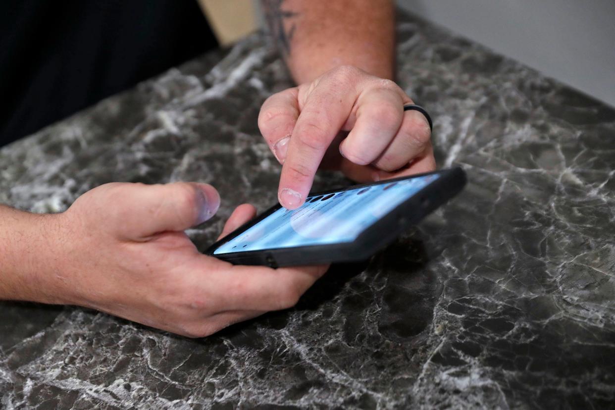 Austin Spain looks at his Facebook Messenger inbox on his phone Wednesday, Feb. 10, 2021. He has two decoy pages that he uses in his search for sexual predators online.