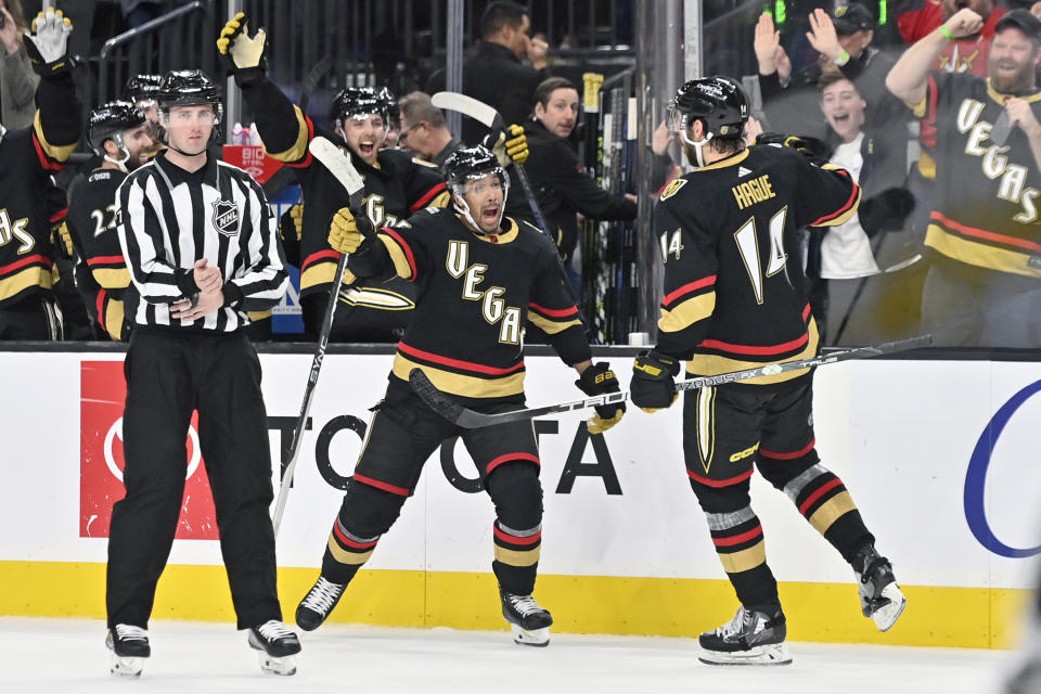 Vegas Golden Knights right wing Keegan Kolesar (55) and defenseman Nicolas Hague (14) react after Hague scored the winning goal during overtime of an NHL hockey game against the Nashville Predators, Saturday, Dec. 31, 2022, in Las Vegas. (AP Photo/David Becker)