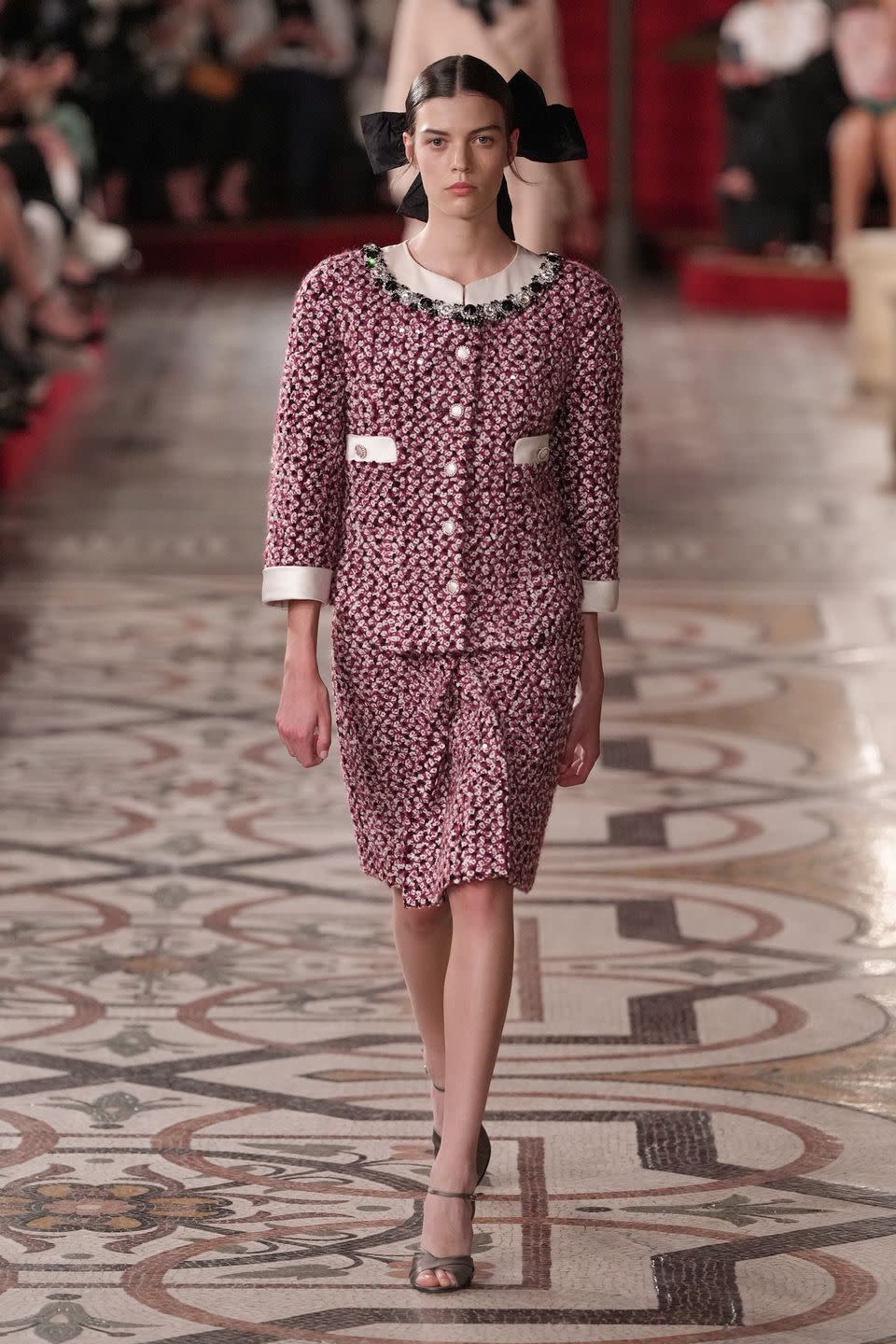 a woman wearing a pink skirt suit