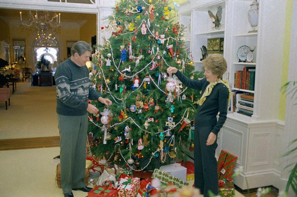 Ronald and Nancy Reagan decorate a Christmas tree at the White House in 1983.