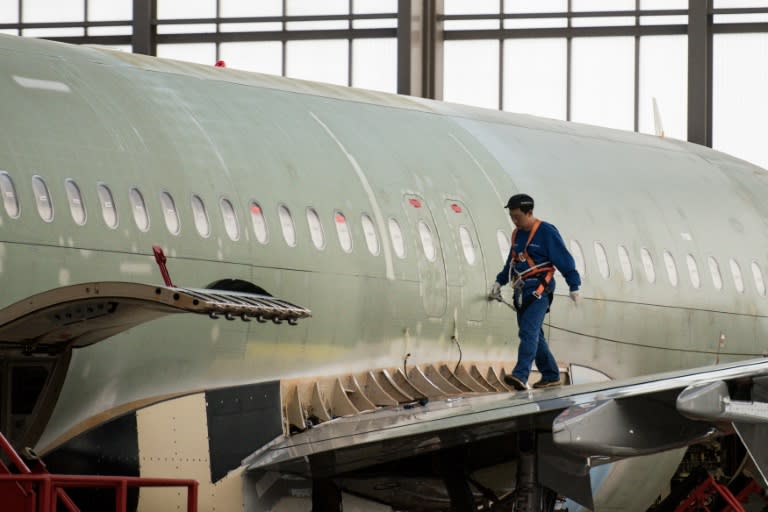 An employee works on the wing root of an aircraft at the assembly floor of the Airbus Tianjin plant