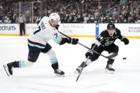 Seattle Kraken right wing Jordan Eberle, left, shoots the puck past Los Angeles Kings defenseman Mikey Anderson during the first period of an NHL hockey game Wednesday, April 3, 2024, in Los Angeles. (AP Photo/Mark J. Terrill)