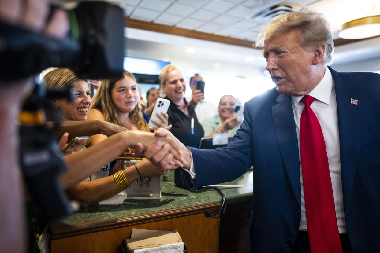 Former President Donald Trump greets people behind the counter at a restaurant in Miami during a campaign stop on June 13, 2023.  (Doug Mills/The New York Times)