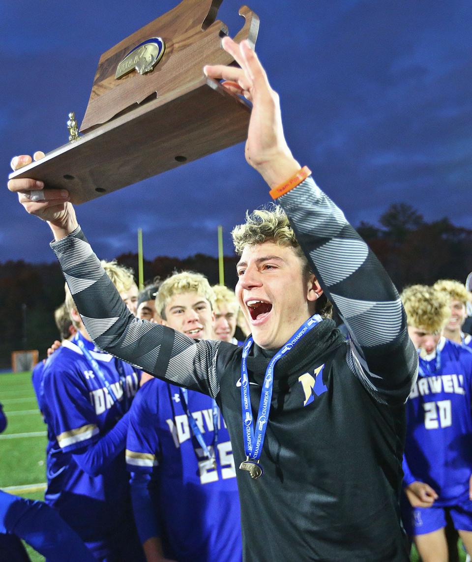 Norwell goalkeeper Nolan McKenna hoists the Div. 3 state championship trophy after the Clippers beat Pembroke, 5-4, in a penalty kick shootout following a 1-1 draw at Scituate High on Saturday, Nov. 18, 2023.