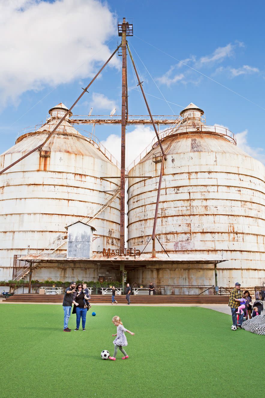 a group of people playing football in front of a large building