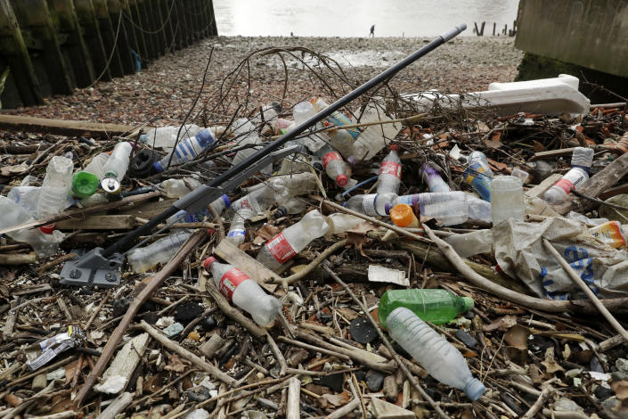 FILE - In this Feb. 5, 2018 file photo, plastic bottles and other plastics including a mop, lie washed up on the north bank of the River Thames in London. European Union officials agreed on Wednesday, Dec. 19, 2018, to ban some single-use plastics, such as disposable cutlery, plates and straws, in an effort to cut marine pollution. The measure will also affect plastic cotton buds, drink stirrers, balloon sticks, and single-use plastic and polystyrene food and beverage containers. (AP Photo/Matt Dunham, File)