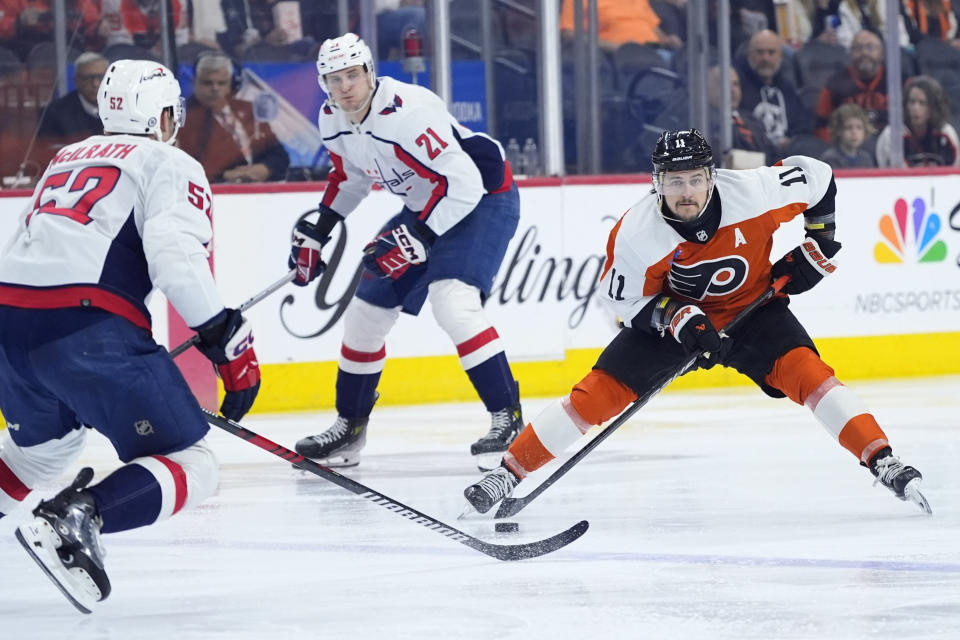 Philadelphia Flyers' Travis Konecny, right, tries to get around Washington Capitals' Dylan McIlrath, left, and Aliaksei Protas during the second period of an NHL hockey game, Tuesday, April 16, 2024, in Philadelphia. (AP Photo/Matt Slocum)