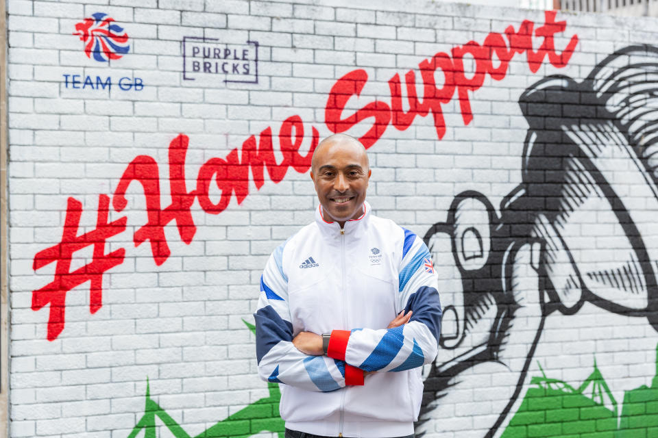 Jackson poses in front of the mural he unveiled as part of the Purple Bricks Home Support campaign in Cardiff.