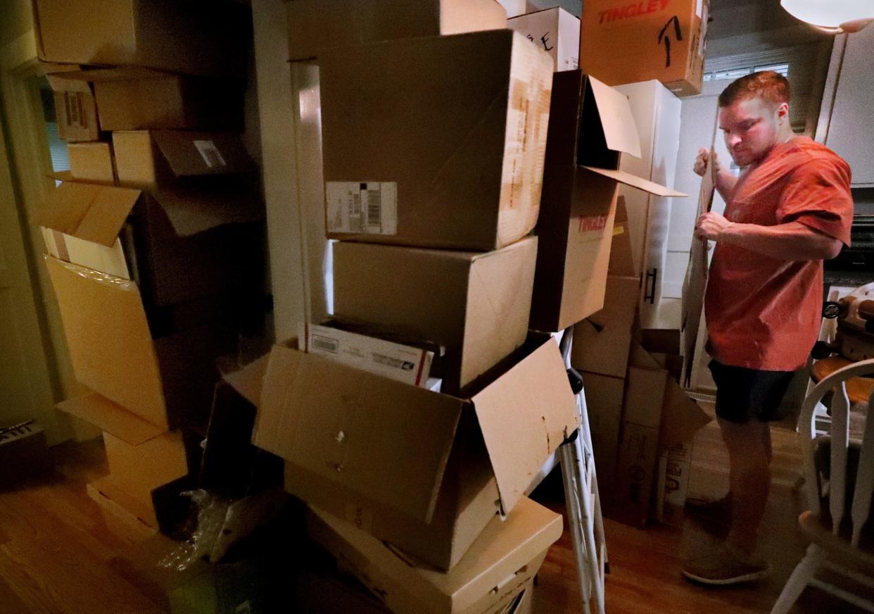 Jake Bolden grabs an empty box from a stack of boxes that goes to the ceiling as he packs in the kitchen of his rental home, in Murfreesboro, on Tuesday, July 18, 2023, as he gets ready to move with his wife Elizabeth Ivey-Bolden, to their first purchased home in Shelbyville.