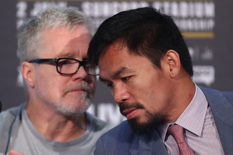 Freddie Roach (L) consults with Manny Pacquiao during a news conference. (Getty)