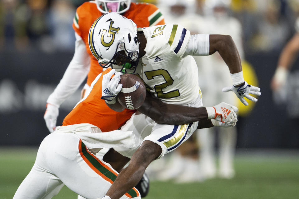 Miami cornerback DJ Ivey, left, hits Georgia Tech wide receiver Malik Rutherford (12) in the second half of an NCAA college football game Saturday, Nov. 12, 2022, in Atlanta. (AP Photo/Hakim Wright Sr.)