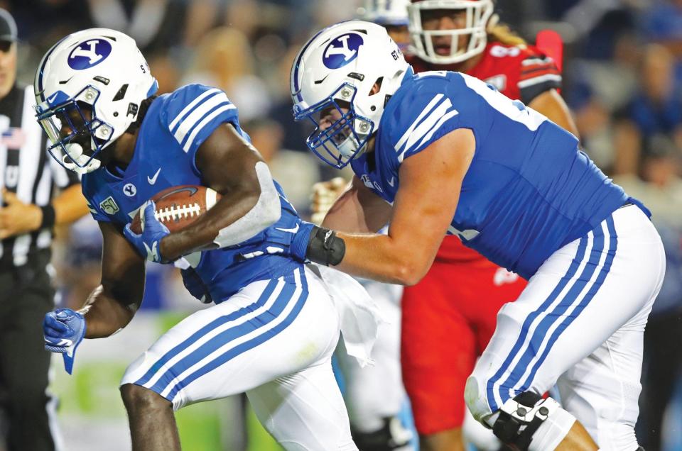 BYU offensive lineman Brady Christensen, right, pushes in running back Ty'Son Williams, left, for a touchdown in the second half during an NCAA college football game, Thursday, Aug. 29, 2019, in Provo, Utah.