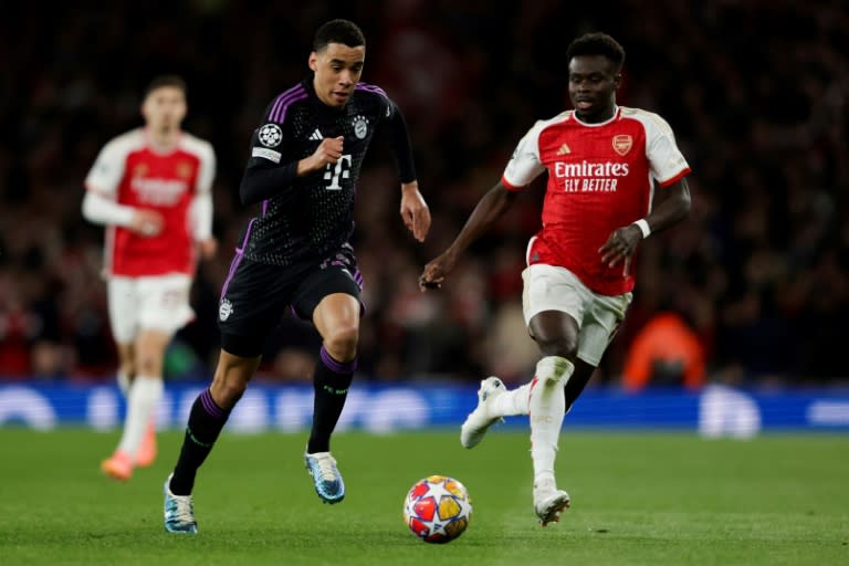 El delantero del Bayern de Múnich Jamal Musiala (izquierda) pugna por el balón con el volante inglés del Arsenal Bukayo Saka durante el duelo de ida de cuartos de Champions Arsenal-Bayern Múnich, en el Arsenal Stadium de Londres, el 9 de abril de 2024 (Ian Kington)