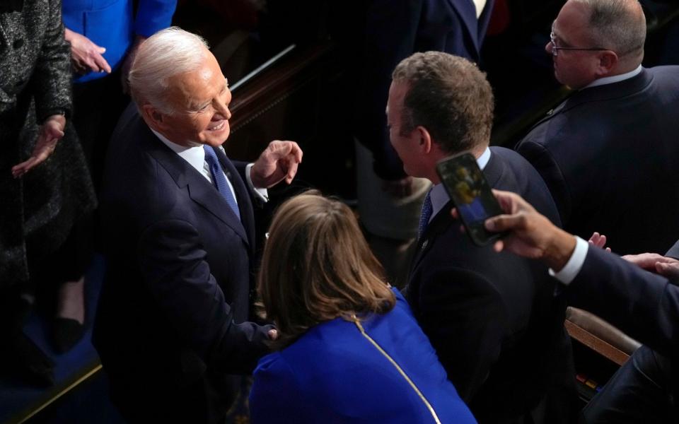  Joe Biden greets people as he arrives in the House chamber - Patrick Semansky/AP