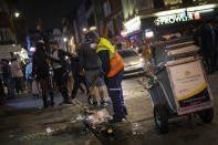 A street cleaner sweeps a street in Soho as late-night drinkers continue into the early hours of Sunday morning as coronavirus lockdown restrictions are eased across England, Sunday July 5, 2020. (Victoria Jones/PA via AP)