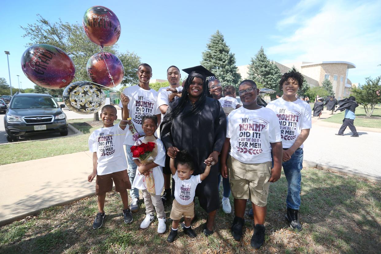 Shilda Fresch, center, with her mother, husband and their eight children before she graduates from Austin Community College Friday, May 13, 2022, at H-E-B Center at Cedar Park. Shilda and her husband Venard Fresch have eight children. From left, Jackson Fresch, Amaziah Stephens, Jakarius Fresch, Johnny Stephens, Zareon Conley and Damarion Fresch. Shilda and Venard are in the process of adopting the youngest twins.
