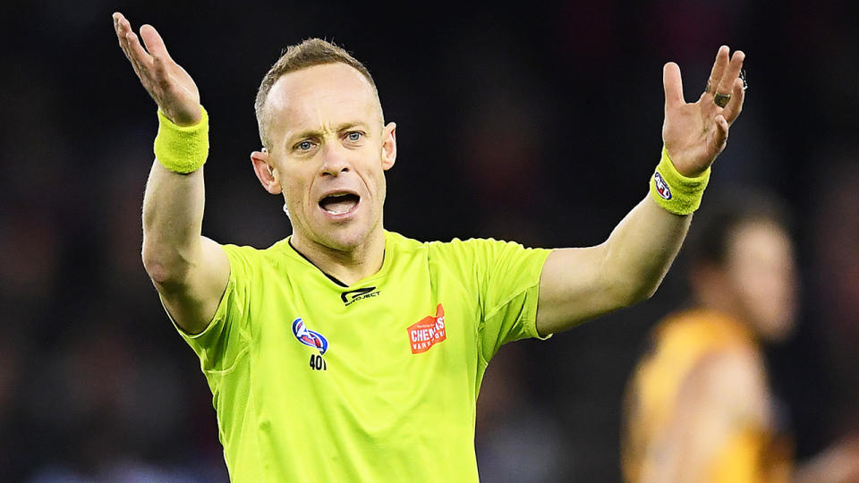 Ray Chamberlain is pictured gesturing while umpiring an AFL match.