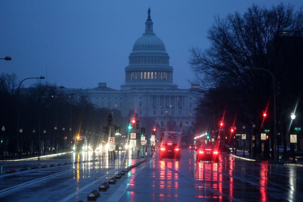 The Capitol is seen early Thursday, Jan. 24, 2019, as rain falls on Pennsylvania Avenue in Washington, with the partial government shutdown in its second month. The Senate will vote on two competing proposals today to end the impasse, but neither seems to have enough votes to advance.