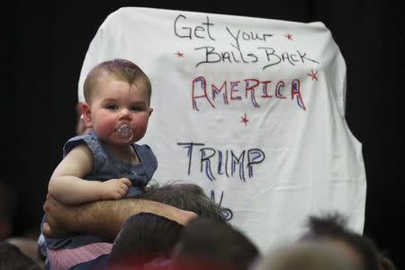 A baby is seen held up on shoulders before Trump speaks at a campaign event at Grumman Studios in Bethpage, New York. REUTERS/Carlo Allegri