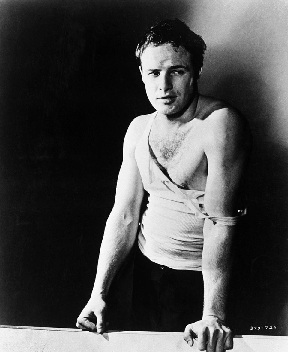 Marlon Brando posing in a ripped white tank top