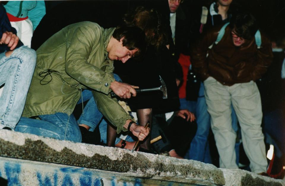 <p>A man uses a small chisel to chip away at a section of the Berlin Wall on 10 November 1989. The wall, which divided East and West Germany, fell the day before, beginning the unification of Germany. Thousands of people came the Berlin in the following days to make their own mark in the destruction of the wall. (AP) </p>