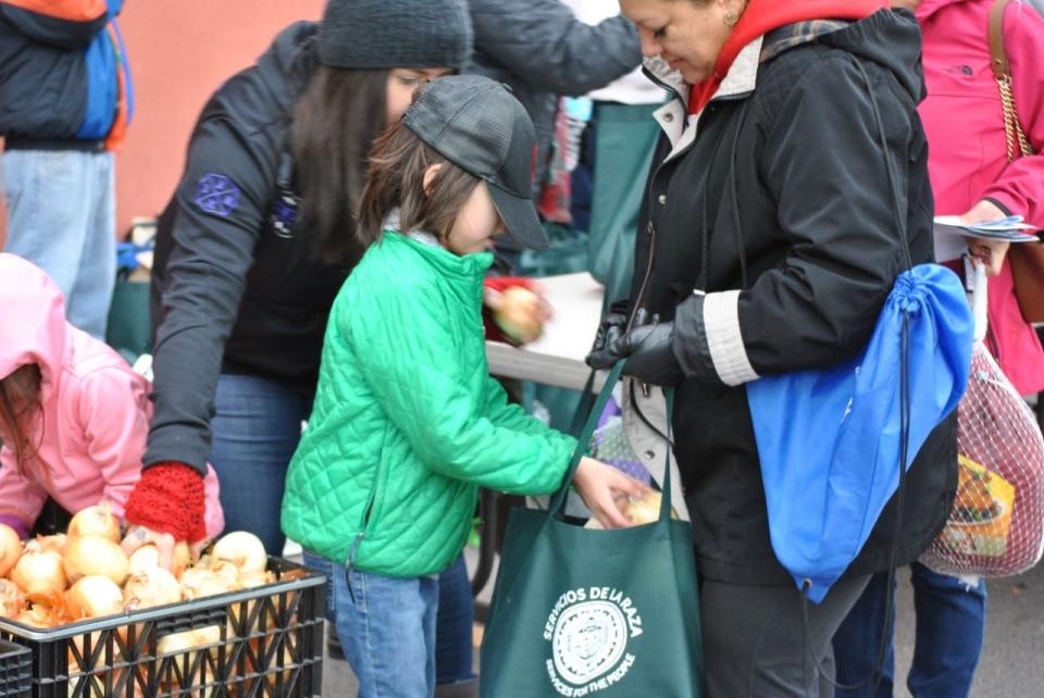 Volunteers help with a Servicios de la Raza food distribution event.