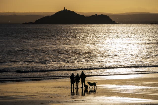 Dog walkers on the beach on New Year's Day at Kinghorn in Fife 