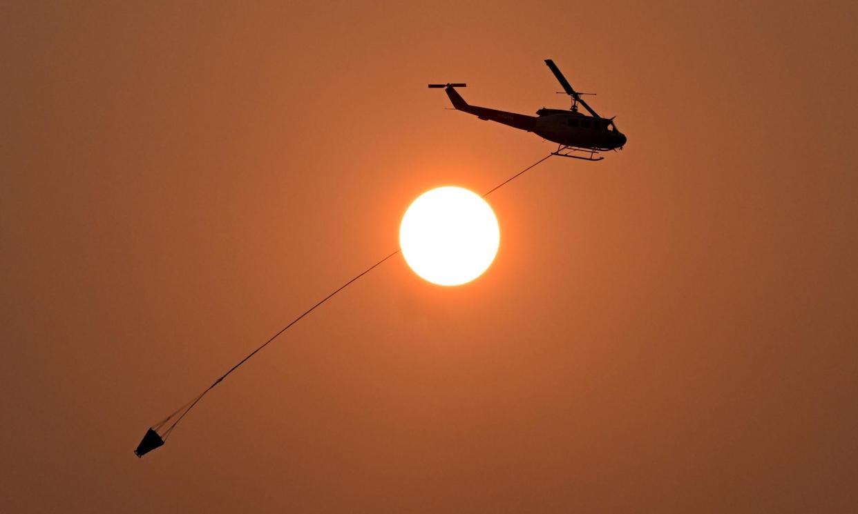 <span>A water-bombing helicopter fights a bushfire in Queensland in November. The Bureau of Meteorology says the 2023-24 El Niño weather event is over.</span><span>Photograph: Darren England/AAP</span>