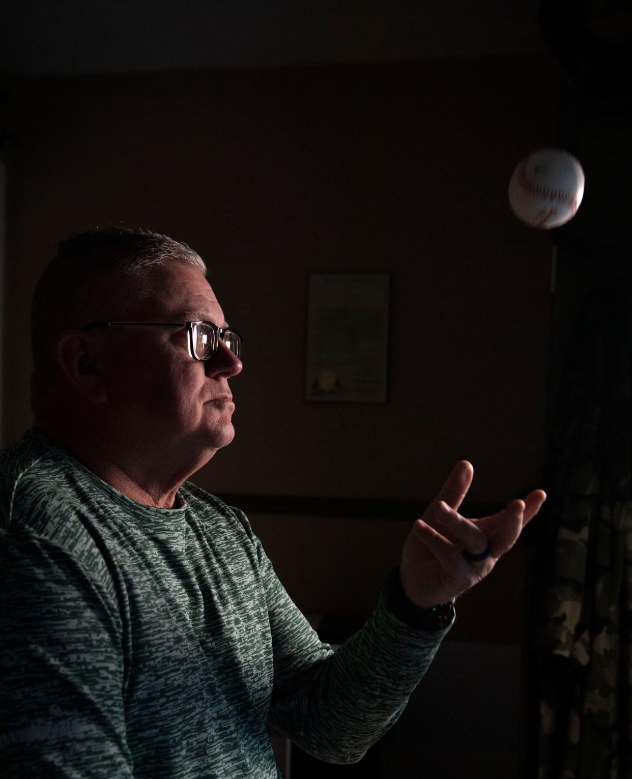 Jeff Edwards, throws a baseball while sitting in a room in his home where his baseball memorabilia is displayed at his home in Mt. Juliet, Tenn., Thursday, March 28, 2024.