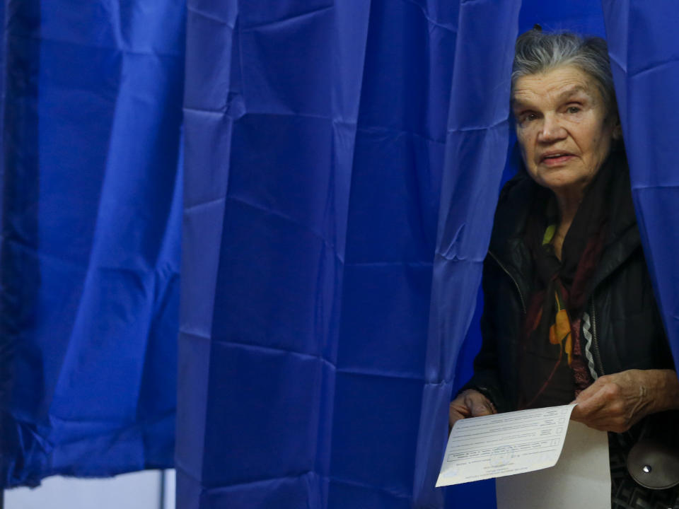 A woman holds her ballot before casting at a polling station during the presidential election in Kiev, Ukraine, Sunday, March 31, 2019. Ukrainians choose from among 39 candidates for a president they hope can guide the country of more than 42 million out of troubles including endemic corruption, a seemingly intractable conflict with Russia-backed separatists in the country's east and a struggling economy. (AP Photo/Efrem Lukatsky)