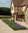 <p> Another way to integrate some greenery into your gravel driveway ideas is with a neat row of flowerbeds. </p> <p> Here, a row of three separate a space for parking from the sleek pathway leading to the house.  </p> <p> Using a matching planting scheme results in a contemporary and orderly aesthetic (and, that lavender will provide a gorgeous summer scent). However, if you're looking for something a little less restrictive, then consider filling them with billowing florals, or perhaps with evergreen ornamental grasses that will offer texture and movement all year long. </p>