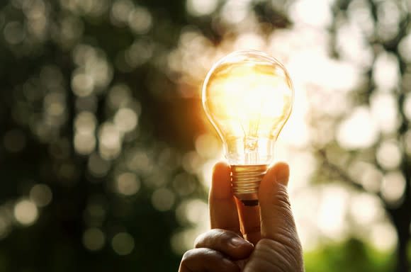 A light bulb being held in the sunlight.