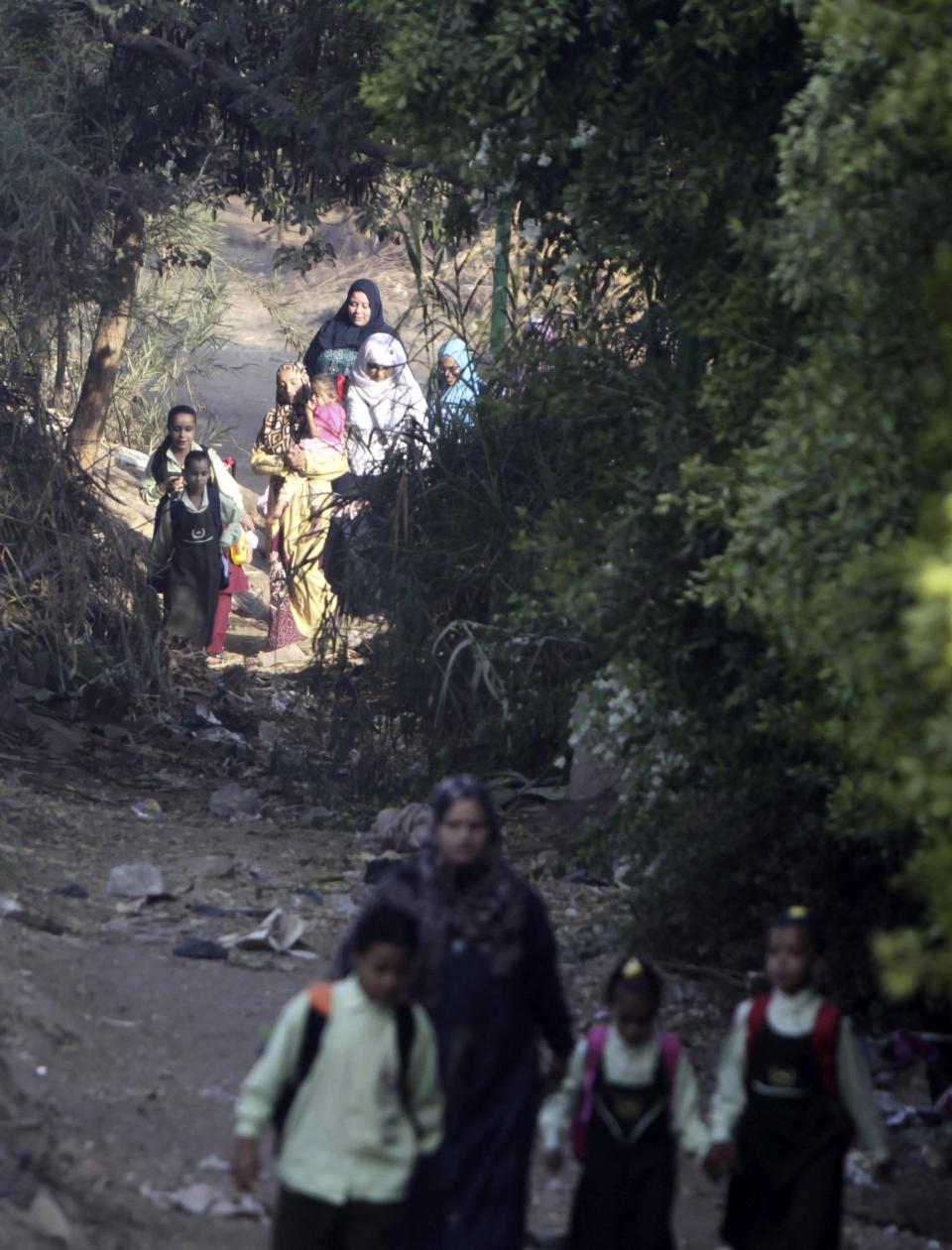 Students walk with their families to school on the first day of their new school year in Giza