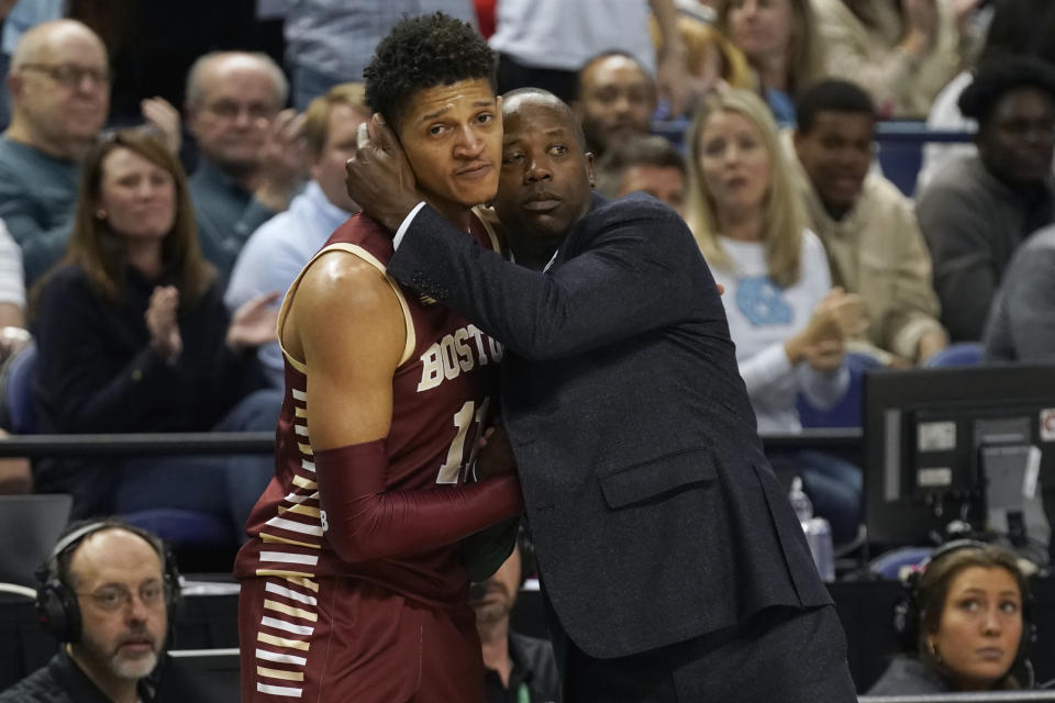 Boston College head coach Earl Grant, right, hugs guard Makai Ashton-Langford, left, late in the second half of an NCAA college basketball game against North Carolina at the Atlantic Coast Conference Tournament in Greensboro, N.C., Wednesday, March 8, 2023. (AP Photo/Chuck Burton)