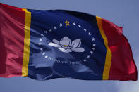 The magnolia centered banner chosen Wednesday, Sept. 2, 2020 by the Mississippi State Flag Commission flies outside the Old State Capitol Museum in downtown Jackson, Miss. The nine member committee voted to recommend a design with the state flower. That design will go on the November ballot for voters consideration and if approved, it will become the new state flag. (AP Photo/Rogelio V. Solis)