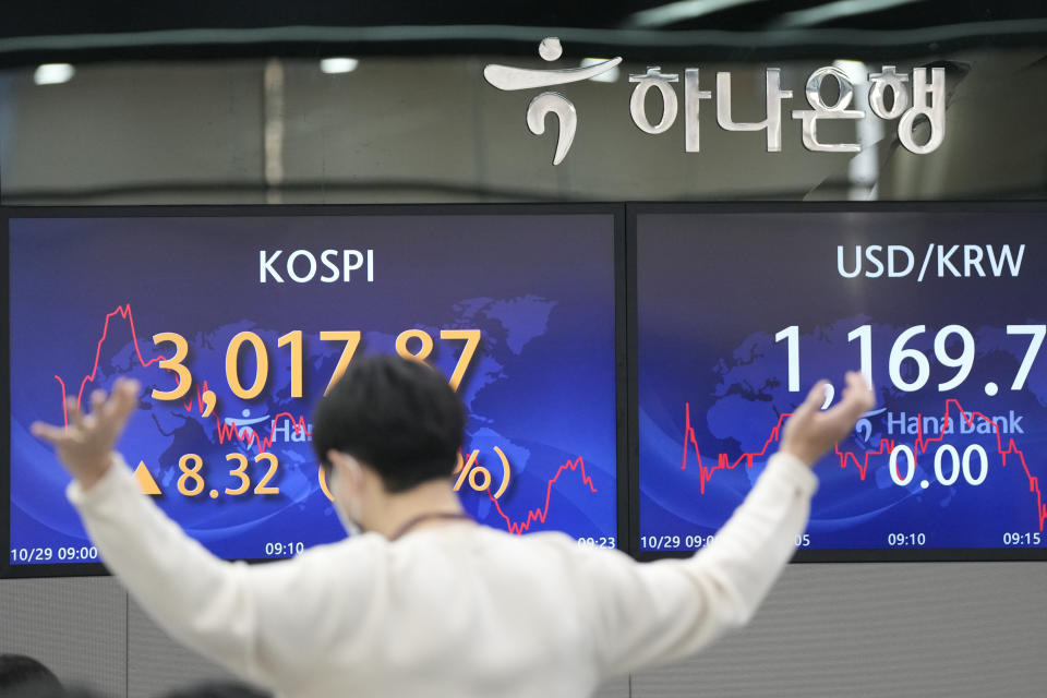 A currency trader gestures near the screens showing the Korea Composite Stock Price Index (KOSPI), left, and the foreign exchange rate between U.S. dollar and South Korean won at a foreign exchange dealing room in Seoul, South Korea, Friday, Oct. 29, 2021. Asian shares slipped on Friday, despite recent signs of optimism about the global economy, including recent rallies on Wall Street.(AP Photo/Lee Jin-man)