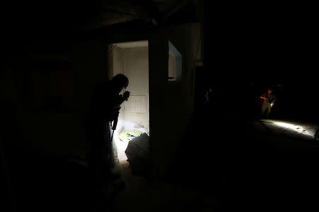 Policemen inspect an empty building, which is used by migrants to shelter themselves after avoiding frontier check points, in a mined area of desert at the Chilean and Peruvian border, in Arica, Chile, November 14, 2018. REUTERS/Ivan Alvarado