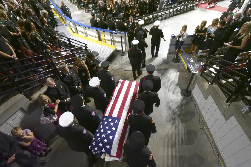 Firefighters carry the casket of Battalion Chief Matt Burchett of the Draper Fire Department into the Maverik Center during funeral services Monday, Aug. 20, 2018, in West Valley City, Utah. Burchett died while fighting a wildfire north of San Francisco. He was flown to a hospital where he succumbed to his injuries. (AP Photo/Rick Bowmer)