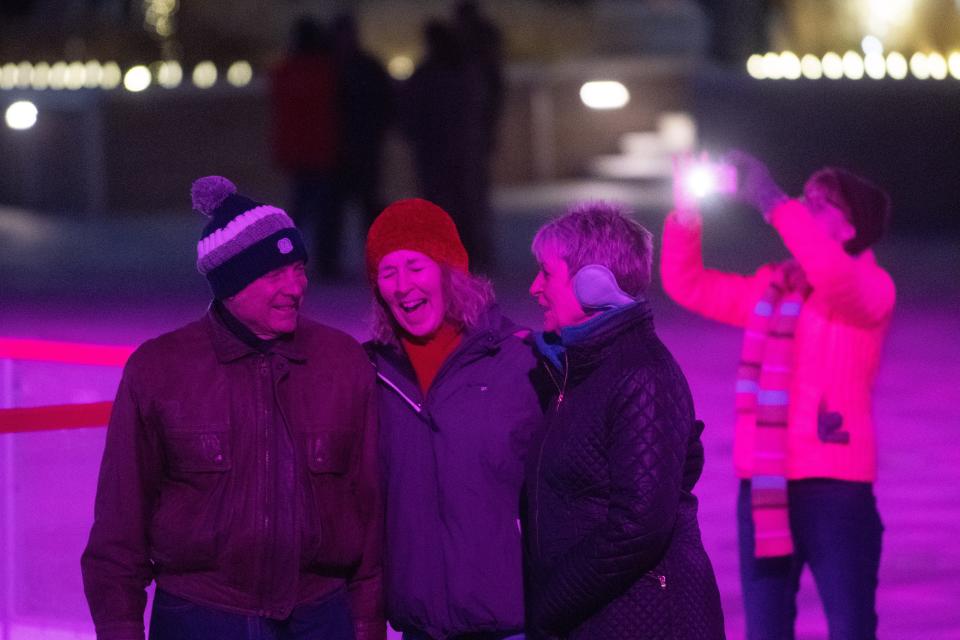 A couple of carolers sing along to the tunes sung by First United Methodist Church singers at Evergy Plaza during the Miracle on Kansas Avenue Parade. An ordinance used to be in place in Topeka banning "yelling, shouting, hooting, whistling or singing" late at night. It was repealed in 2011.