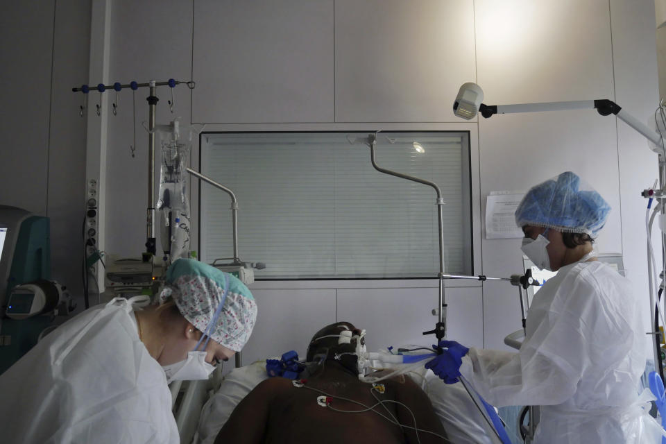 Nurses Stephanie Dias, right, and Segolene Poux tend to a patient affected by COVID-19 virus in the ICU unit at the Ambroise Pare clinic in Neuilly-sur-Seine, near Paris, Friday, March 19, 2021. French Prime Minister Jean Castex announced new coronavirus restrictions as the number of COVID-19 patients in intensive care units spikes. (AP Photo/Thibault Camus)