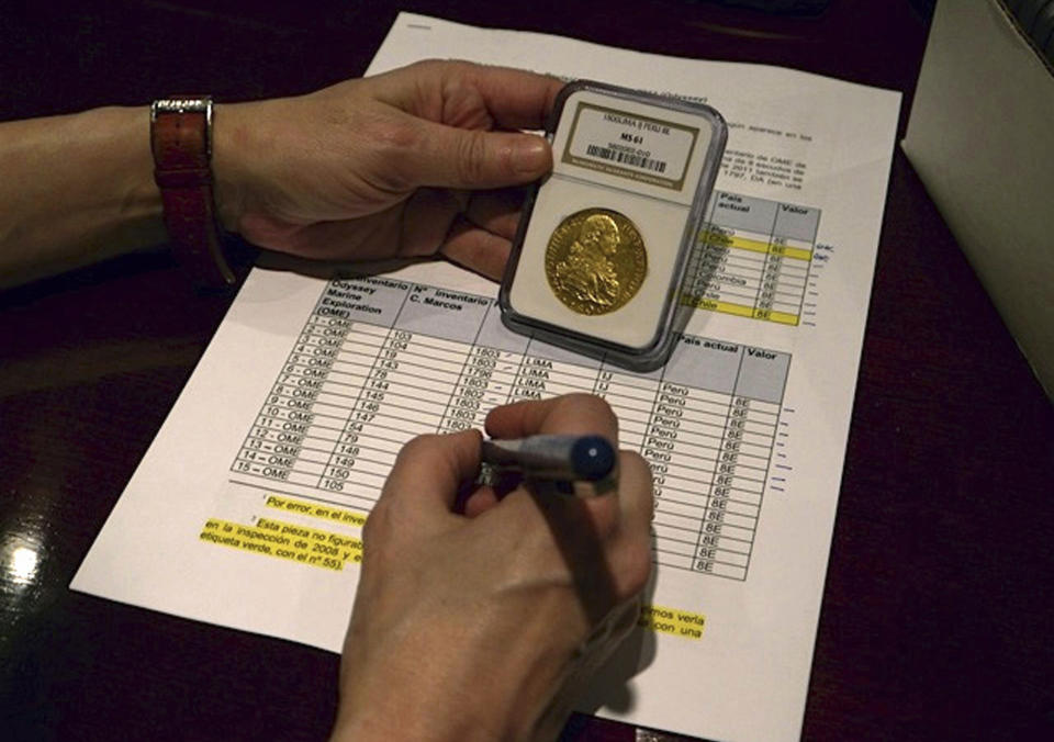 In this undated photo made available by the Spain's Culture Ministry, a member of the Ministry technical crew works with one of the 594,000 coins and other artifacts found in the Nuestra Senora de las Mercedes, a Spanish galleon sunk by British warships in the Atlantic while sailing back from South America in 1804, in a warehouse in Tampa, Fla. A 17-ton trove of silver coins recovered from the Spanish galleon was set to be flown Friday Feb. 24, 2012 from the United States to Spain, concluding a nearly five-year legal struggle with Odyssey Marine Exploration, the Florida deep-sea explorers who found and recovered it. (AP Photo/Spain's Culture Ministry)