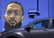 A motorist drives past a street mural of the late rapper Nipsey Hussle, Thursday, June 30, 2022, in downtown Los Angeles. The many murals of Hussle around Los Angeles speak to the late rapper's lasting legacy. (AP Photo/Chris Pizzello)