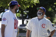 **Photo holds for Jordan Cohen's story** Chicago Cubs fans wait for a ball outside of Wrigley Field before the Opening Day baseball game between the Chicago Cubs and the Milwaukee Brewers in Chicago, Friday, July 24, 2020, in Chicago. The Chicago Cubs open against the Milwaukee Brewers. In a normal year, that would mean a sellout crowd at Wrigley Field and jammed bars surrounding the famed ballpark. But in a pandemic-shortened season, it figures to be a different atmosphere. (AP Photo/Nam Y. Huh)