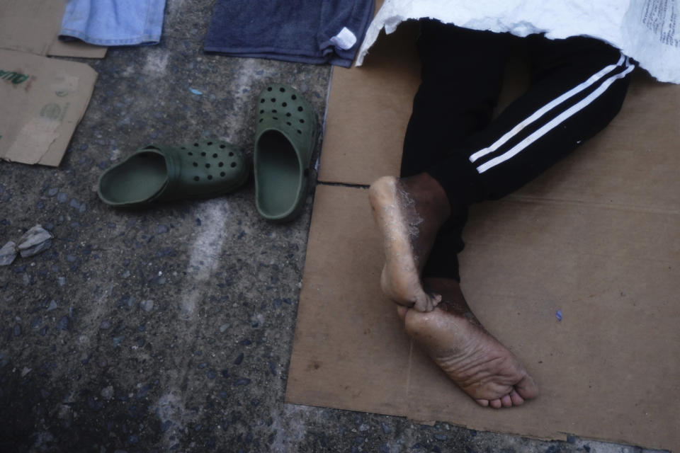 Migrants sleep-in on the street in Huixtla, Chiapas state, Mexico, at daybreak Tuesday, Oct. 26, 2021, as they use the day to rest during their ongoing trek by foot toward the U.S. (AP Photo/Marco Ugarte)